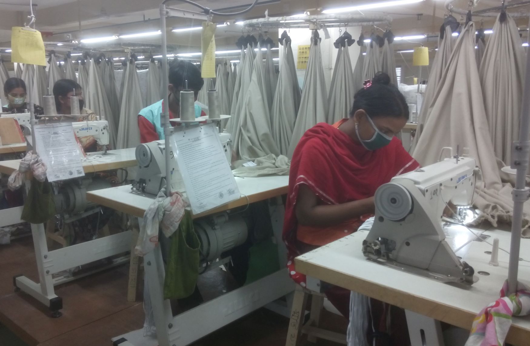 Arbeiterinnen an Nähmaschinen in einer Textilfabrik